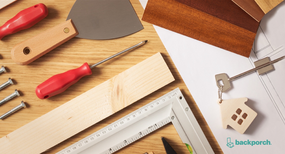 carpentry tools laid out on a workbench next to home plans